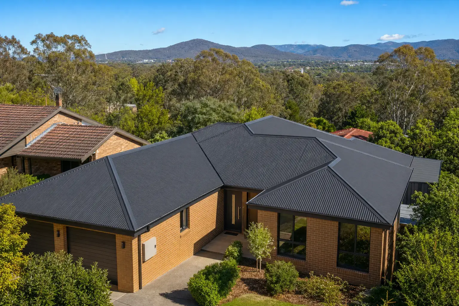 New charcoal Colorbond metal roof on a Canberra home with the Brindabella ranges behind